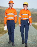 Two individuals wear unisex cotton stretch ripstop work pants in navy, paired with bright orange shirts and hard hats.