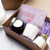 A6 message card in lavender with candles and a jar of bath salts, displayed in a brown gift box with purple filler.