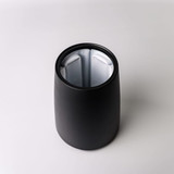 A black ice bucket with a sleek design, featuring a reflective inner surface and a logo.
