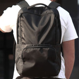 A black backpack with multiple compartments and a logo, designed for carrying laptops and other items.