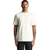 A plain cream t-shirt worn by a man with tattoos, featuring a simple design and a logo on the chest.