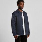 A work jacket in navy blue, featuring a collar and button-up front, worn by a standing male model.
