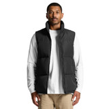 A puffer vest in black, featuring a zip closure and a high collar, worn over a white long-sleeve shirt.