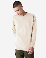 A long-sleeve beige t-shirt with a pocket and a crew neck, displayed by a model wearing olive green pants.