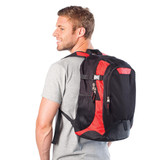 A black and red laptop backpack is worn by a smiling man, showcasing its design and functionality.