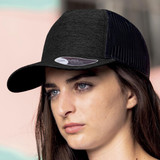 A black cap with a mesh design and a logo, worn by a model against a pastel background.