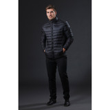 A stylish black puffer jacket displayed on a model standing against a dark background, featuring a logo on the chest.