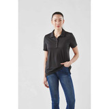 A woman wearing a black short sleeve polo shirt with a collar, featuring a logo, paired with blue jeans.