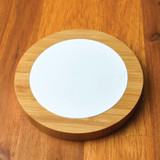A Bamboo Ranger Fast Wireless Charger featuring a bamboo base and a smooth white charging surface.
