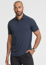 A short sleeve polo shirt in navy blue, featuring a collar and a logo on the chest, worn by a male model.