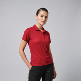 A red women's polo shirt featuring a collar and a branded logo.
