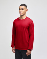 A red long-sleeve t-shirt on a model, featuring a small logo on the sleeve. The fabric appears soft and casual.