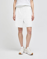 Light grey cotton gym shorts with an elastic waistband, featuring a logo, worn by a person with white sneakers.