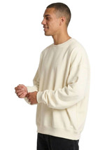An oversize cream fleece crew neck sweatshirt displayed on a model. The sweatshirt features long sleeves and a relaxed fit.
