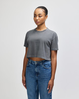 A grey cropped boxy t-shirt for women, featuring a relaxed fit and short sleeves. It has a logo on it.