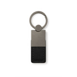 A sleek, black leather keytag with a metallic silver keyring attachment and minimalist design.