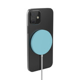 A black smartphone with a teal circular magnetic wireless charger attached, featuring a charging cable.
