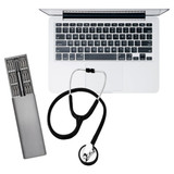 A silver tool kit with various bits, a black stethoscope, and a silver laptop keyboard. The kit includes a logo.