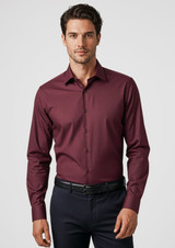 A maroon long sleeve button-up shirt with a fitted design and a logo. Styled with dark trousers.