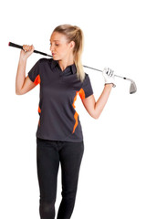 A woman holds a golf club over her shoulder while wearing a dark grey polo shirt with orange accents.