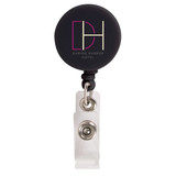 A retractable name badge holder in black with a clear strap and a circular logo attachment.