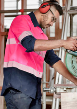 A long sleeve work shirt featuring segmented high visibility pink and navy sections, with a logo displayed on the chest.