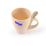 A drinkware cup in beige with a spoon attached, featuring a logo on its side.