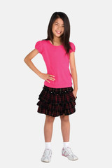 A pink short puff sleeve T-shirt paired with a black plaid skirt, worn by a smiling girl.