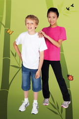 A white bamboo cotton T-shirt and a pink bamboo cotton T-shirt worn by children against a green bamboo backdrop.