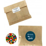 A kraft paper bag containing chewy fruit candies in vibrant colours, alongside a branded circular logo.