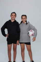 Two girls wearing hoodies, one in black and the other in grey, holding a soccer ball, standing together.