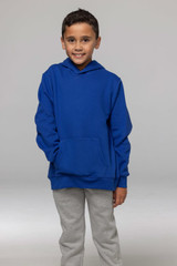 A child in a blue hoodie with a front pocket, wearing grey pants, posing against a neutral background.