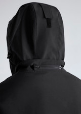 A black rain jacket featuring a hood and a rear zipper detail. The jacket includes branding.