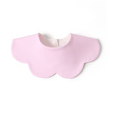 A pink baby bib with a scalloped design, made from 100% organic cotton interlock fabric. It has a button closure.