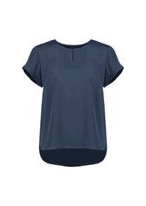 A women's short sleeve blouse in navy blue with a round neckline and a slightly longer back hem. It features rolled sleeves.