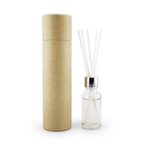 A clear glass reed diffuser bottle with a silver cap and white reeds, packaged in a brown cylindrical box.