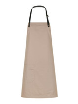 A beige bib apron with a waist pocket and a black adjustable neck strap, featuring a branding logo.