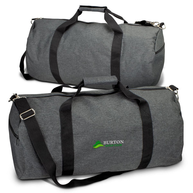A grey duffle bag with black straps and a branding logo. The bag features a large zippered compartment.