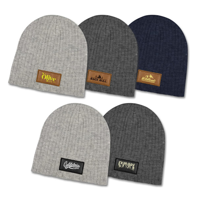 A collection of Nebraska Heather cable knit beanies in grey, navy, and charcoal with various patches.