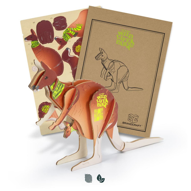 A wooden kangaroo model in brown, featuring various pieces and a design template, presented in a cardboard package with a logo.
