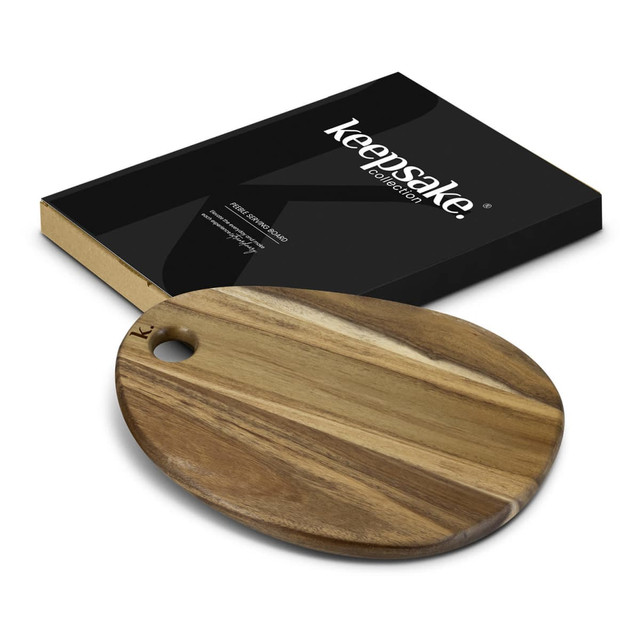 A wooden oval serving board in natural tones beside a black box with a logo.