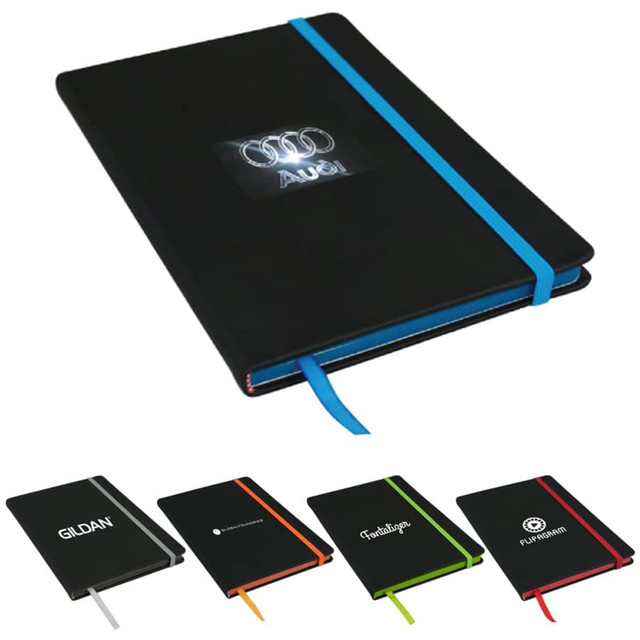 A black A5 journal with an elastic band in blue, featuring various other coloured journals in the background.