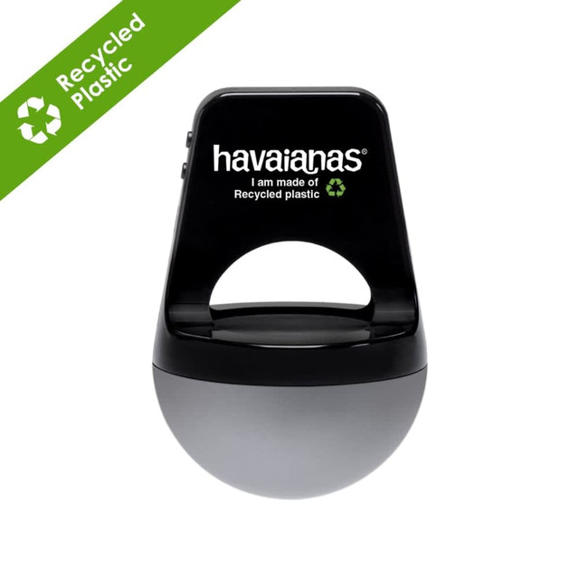 A silver wireless speaker made from recycled ABS plastic, featuring a black handle and branding.