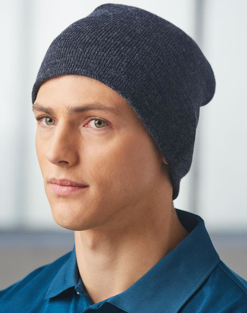 A dark navy acrylic knitted marl beanie worn by a model with light skin and short hair.
