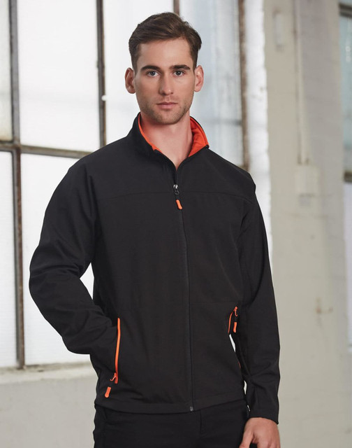 A men's softshell jacket in black with orange accents, featuring a zippered front and pockets. It has a logo.