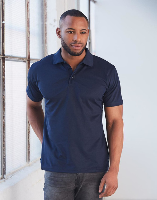 A man models a navy blue short-sleeved polo shirt, featuring a collar and a logo on the chest.