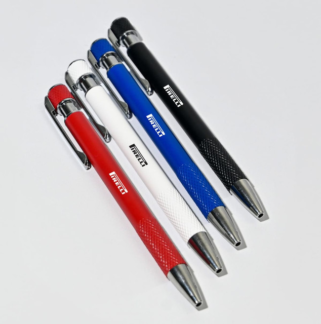 A collection of five ball pens in red, white, blue, black, and silver, featuring a textured grip and a logo.