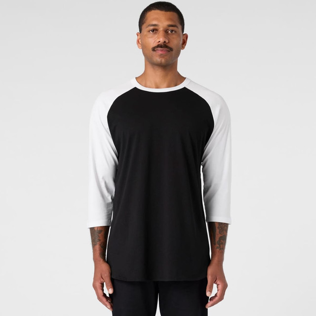 A black and white Raglan Tee featuring a crew neck and three-quarter sleeves, with a logo present.