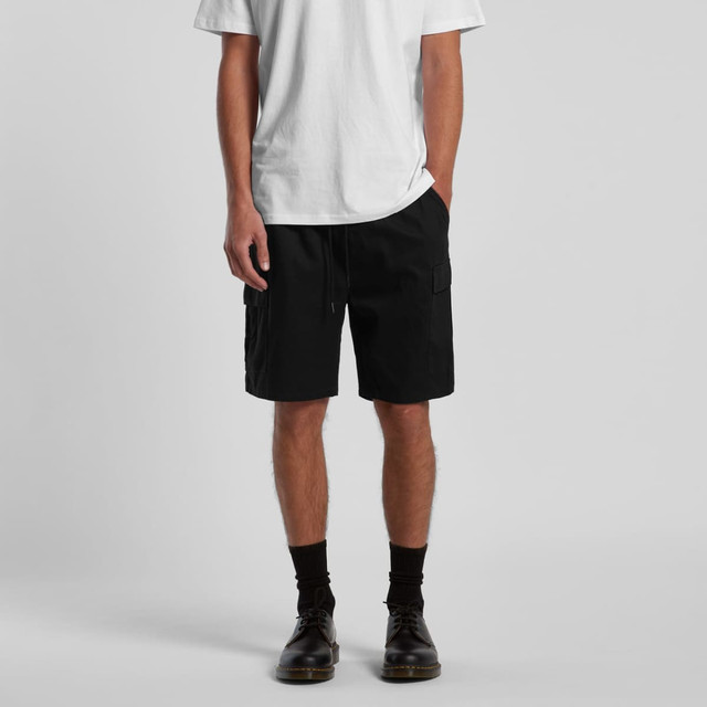 Cargo Walk Shorts in black, featuring side pockets and a drawstring waist. Styled with a plain white t-shirt and black footwear.