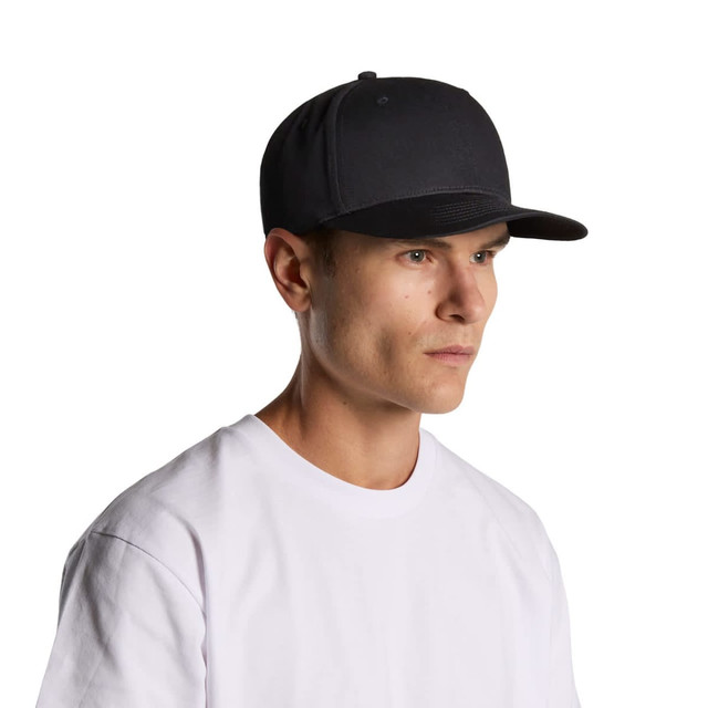 A dark grey cap is worn by a model with short hair, paired with a plain white t-shirt. The cap has a logo.